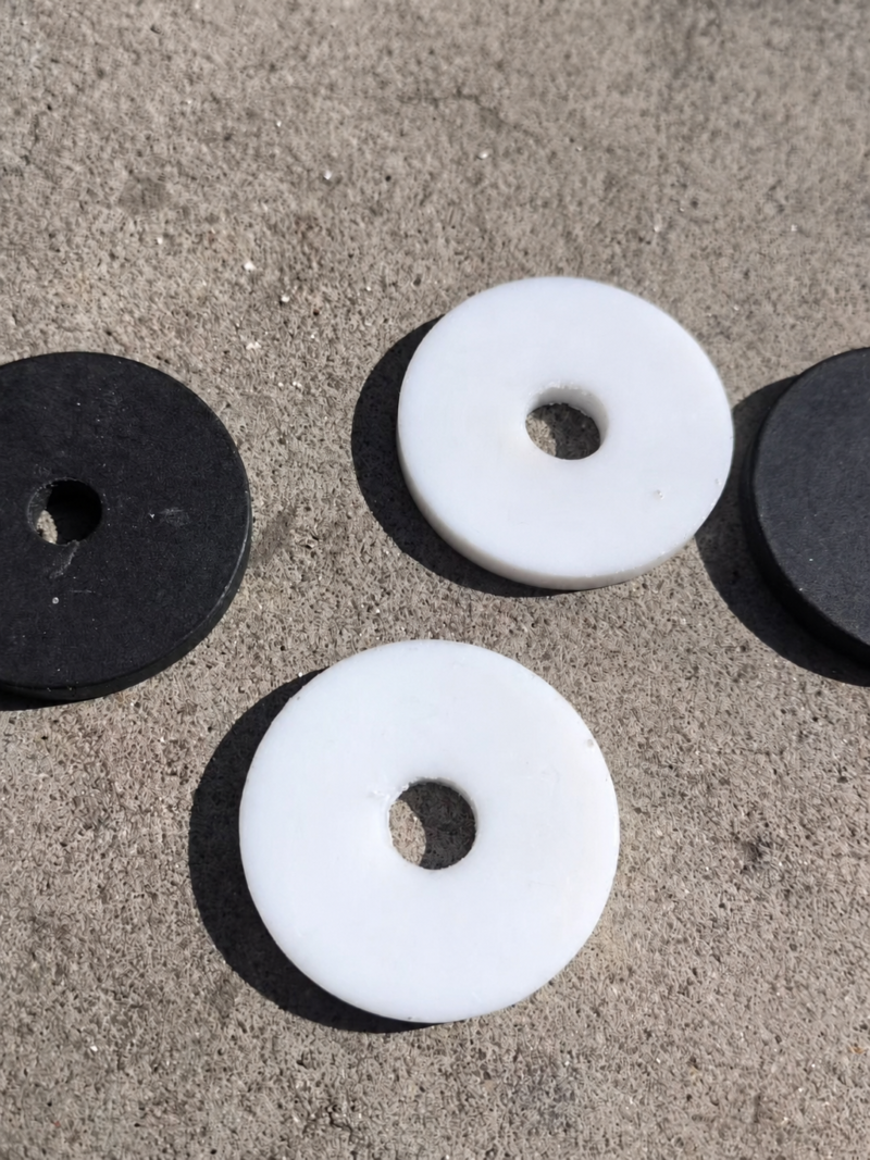 IKSONIC white flat washers with central bores and partially cropped dark washers.