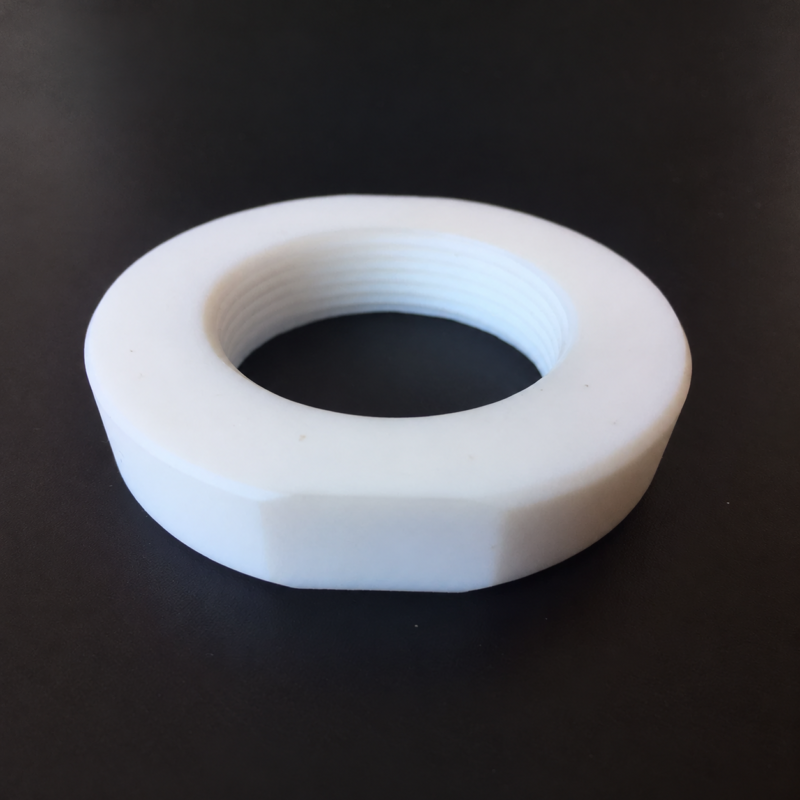 Close-up of a white PTFE hex nut showing its internal threads, available from IKSONIC