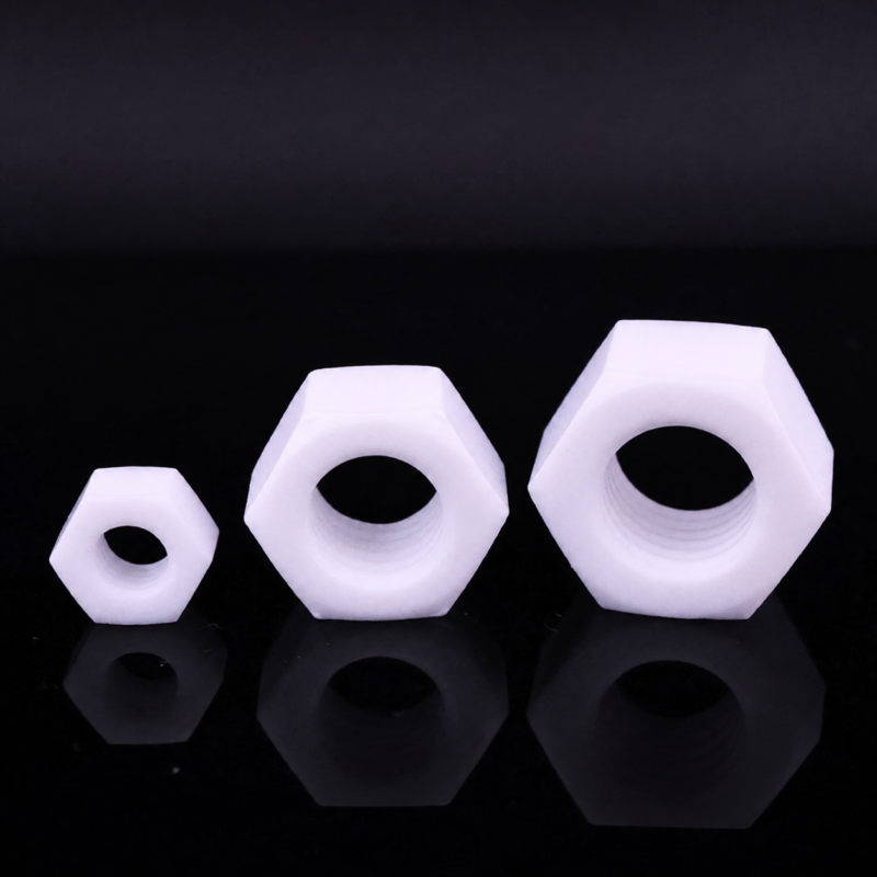 iksonic-ptfe-hex-nuts-china-supplier Three white PTFE hex nuts in different sizes with visible internal threads, supplied by IKSONIC in China