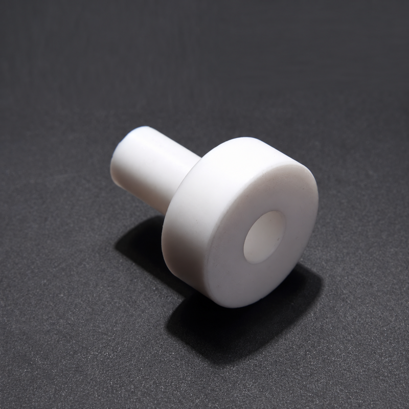 Close-up of a white PTFE shoulder bushing with a wide flange and narrow sleeve, IKSONIC China supplier