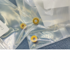 Three yellow ring seals on clear supplier packaging, with two metal spring inserts visible and one reverse-face view.
