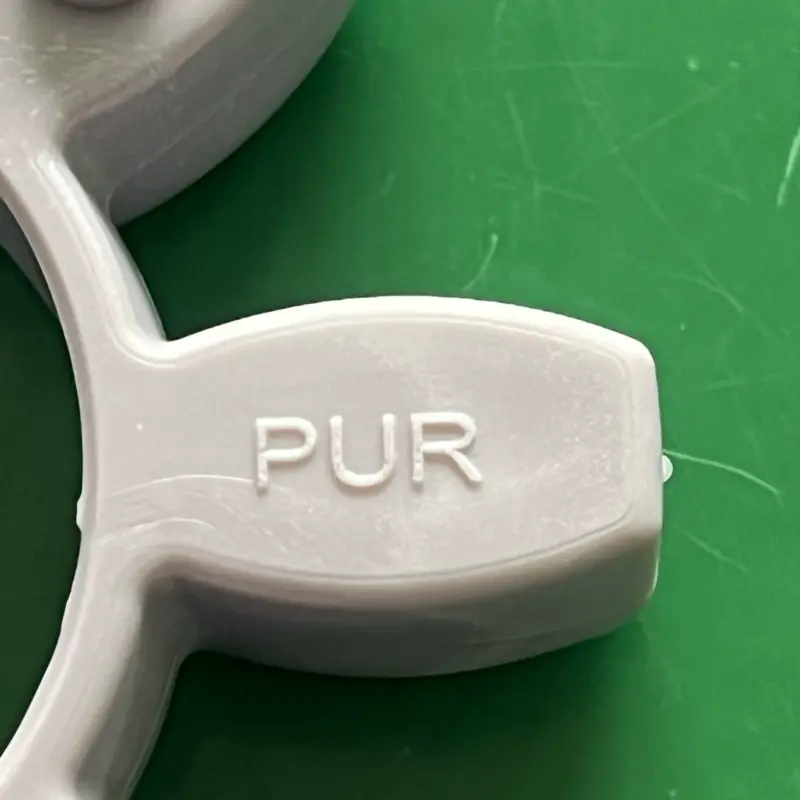 Close detail of PUR molded lettering on a grey coupling insert, IKSONIC China supply