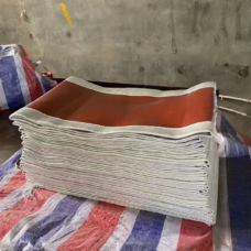 Folded red-coated fabric expansion joint skins showing layered white edges.
