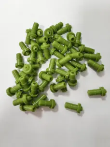 Green rubber dispensing nozzle assortment showing open bores and profiles, available wholesale from IKSONIC.