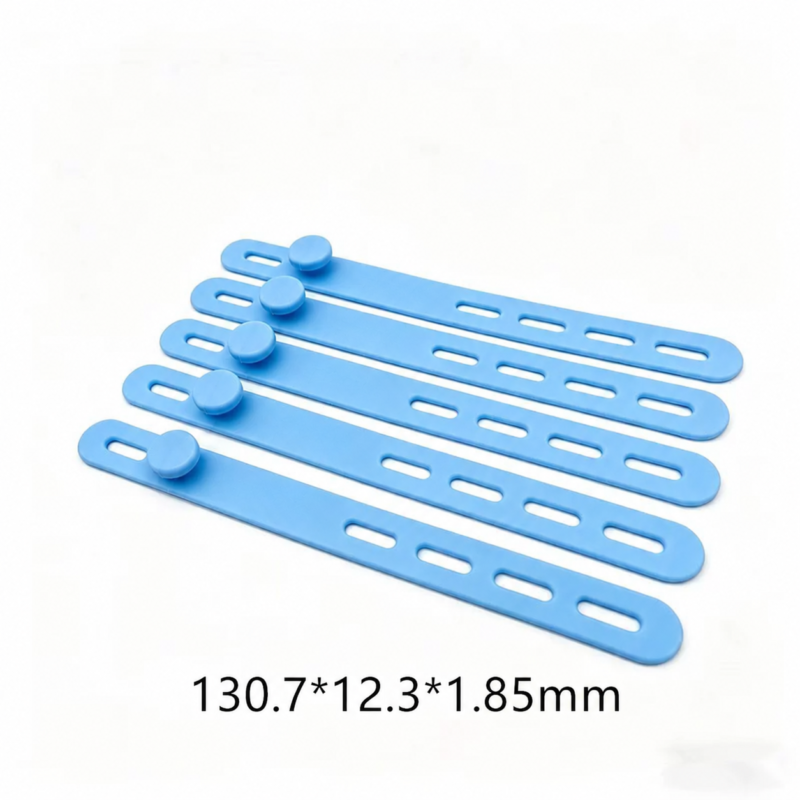 Angled view of five IKSONIC silicone cable ties showing adjustment slots, fastening studs and 130.7 × 12.3 × 1.85 mm dimensions.