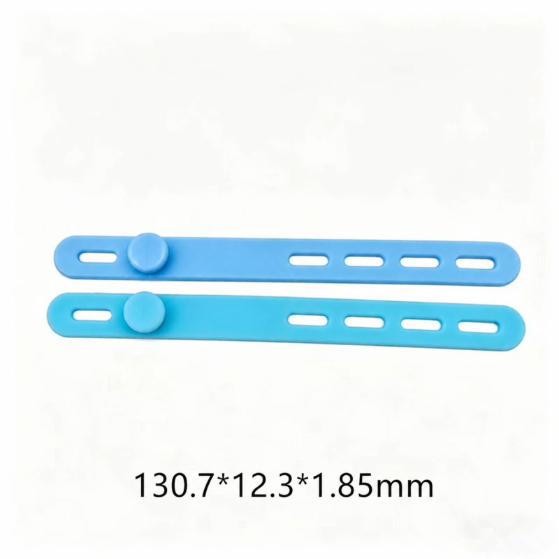 IKSONIC silicone cable ties in light blue and lake blue, showing fastening studs, adjustment slots and 130.7 × 12.3 × 1.85 mm dimensions.