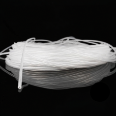 Coiled transparent silicone capillary tubing on a black reflective surface, with one open tube end visible.