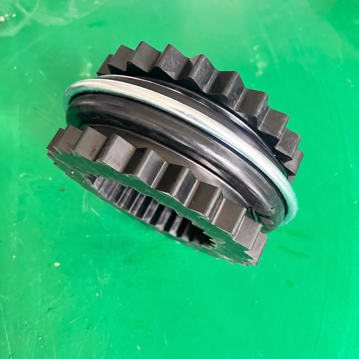 Side view of a split toothed flexible coupling ring with a metal retaining ring, supplied by IKSONIC