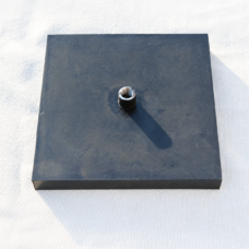 Square black inflatable rubber airbag pad with one central air inlet on a light woven background.