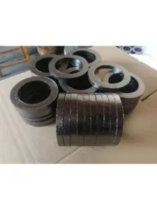 IKSONIC graphite packing rings stacked on their edges in front of additional ring stacks.