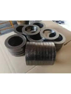 Graphite packing rings stacked on their edges in front of additional ring stacks.