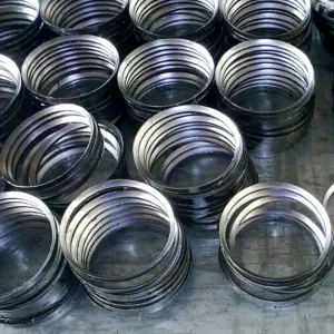 Multiple stacks of IKSONIC beveled graphite sealing rings arranged on a work surface.