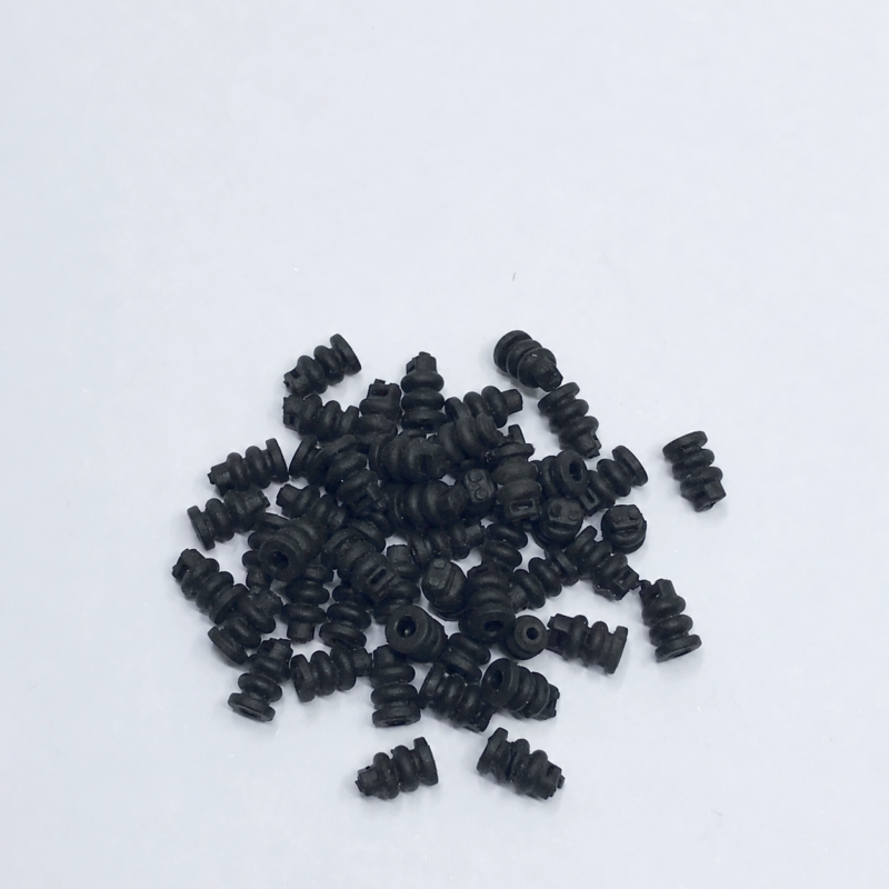 iksonic-supplier-mavic-air-2-gimbal-dampers-bulk-view Black gimbal dampers arranged in a loose pile on a light background, listed by the supplier for DJI Mavic Air 2 repair.