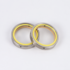 Overlapping vacuum pump shaft seals showing yellow sealing rings and metal housings, IKSONIC supplier