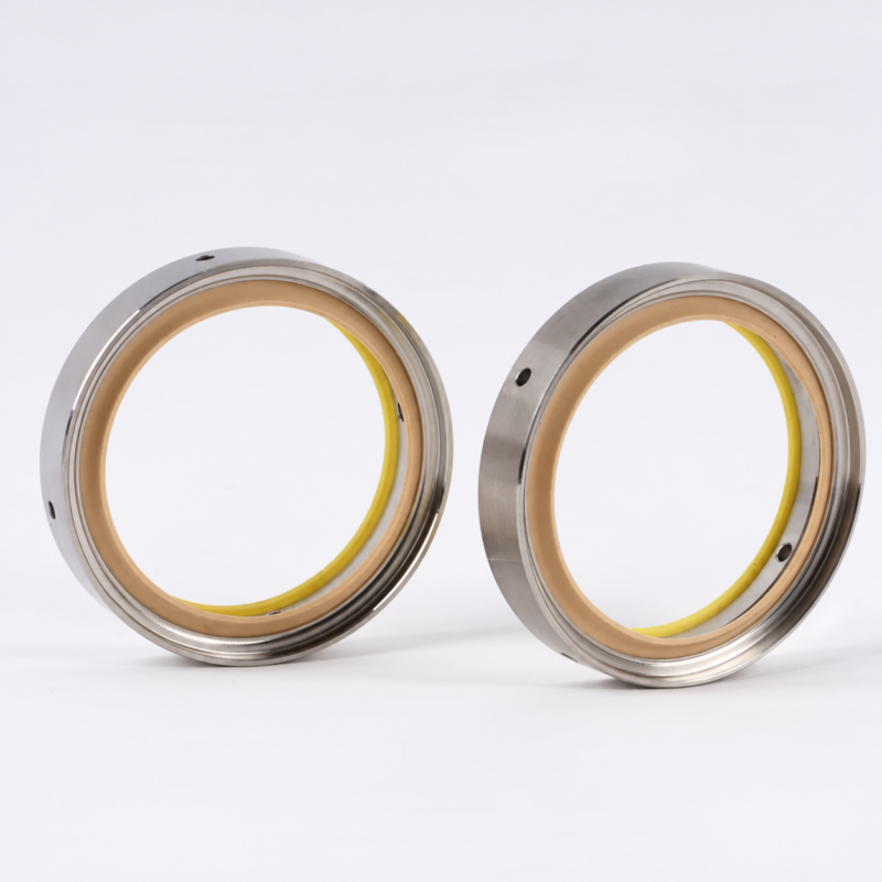 iksonic-vacuum-pump-shaft-seal-supplier-front-view Two vacuum pump shaft seals showing tan inner lips and metal housings, supplied by IKSONIC