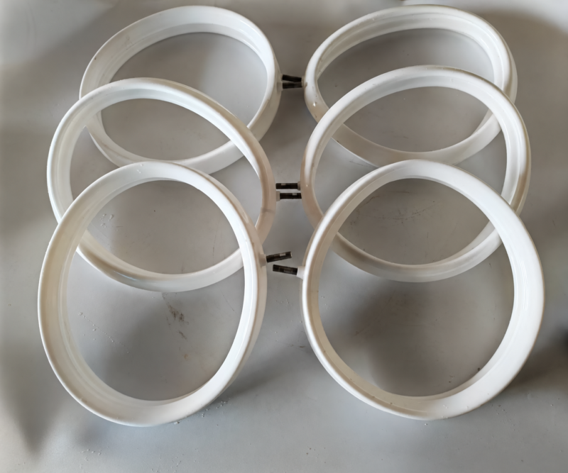 iksonic-white-inflatable-sealing-rings-group Six white IKSONIC annular inflatable sealing rings with air inlets arranged on a gray surface.