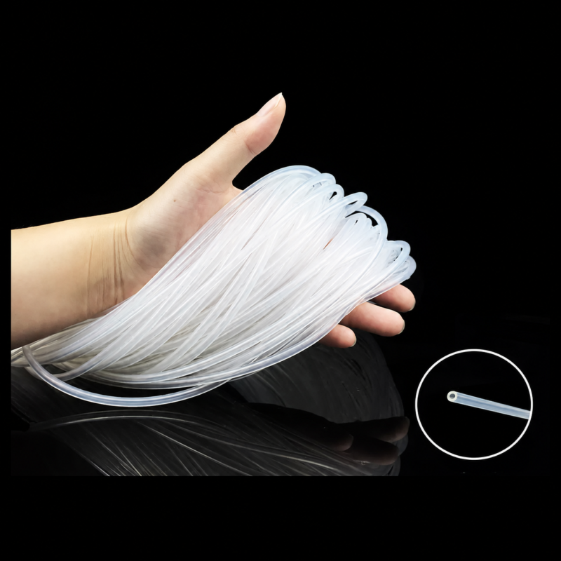 A hand holding a bundle of transparent silicone capillary tubing, with a circular close-up of an open tube end.