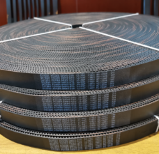 Large coils of open-ended toothed belts with printed Gates PowerGrip markings.