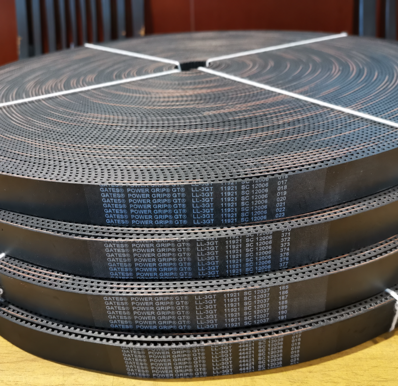 Imported GATES Open-Ended Timing Belts - LL Series Large coils of open-ended toothed belts with printed Gates PowerGrip markings.