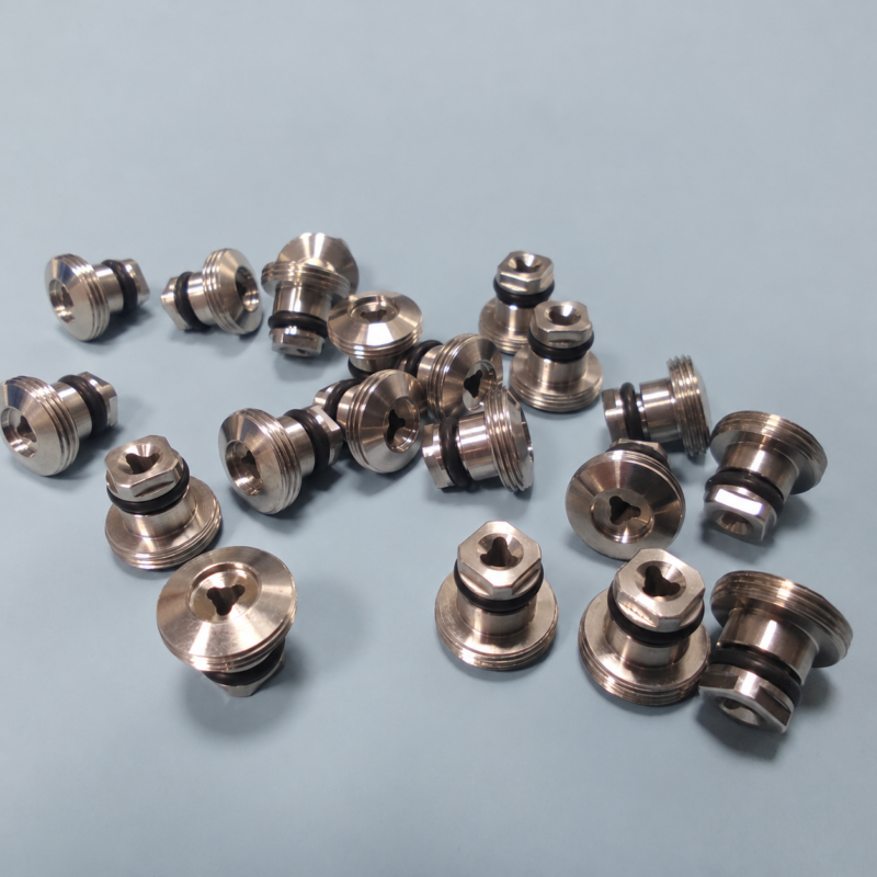 Metal nozzle components with stepped profiles, threaded rims, dark sealing rings and shaped openings.