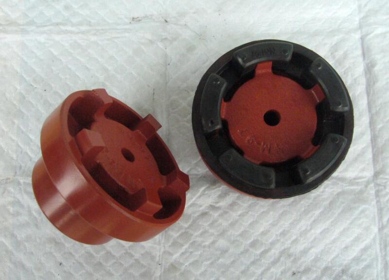 Black flexible coupling insert fitted around a red coupling hub, beside a separate hub.