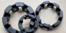 Three black NM coupling inserts with raised inward-facing blocks, shown in a close crop.