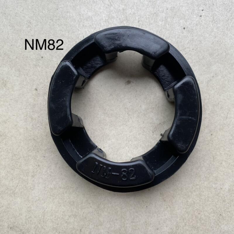 Black NM82 flexible coupling insert showing four inward-facing pads and molded model marking.