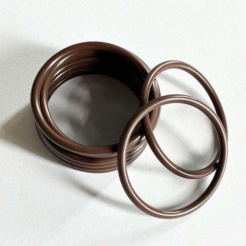 Brown round-section O-rings stacked with two rings leaning across the front.