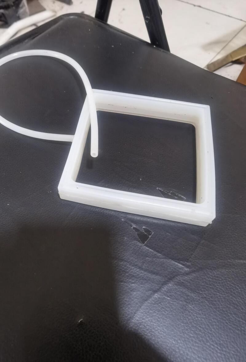 White rectangular inflatable seal with an attached flexible inflation tube.