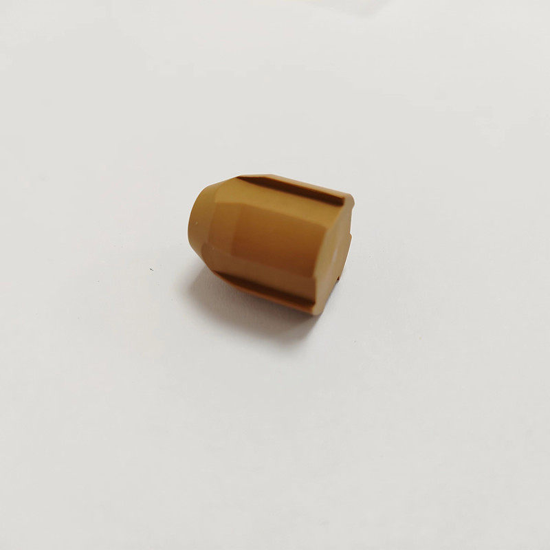 Brown ribbed valve component resting on its side on a white surface.