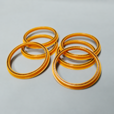 Six yellow annular seals in overlapping groups, with metal spring elements visible along their inner edges.