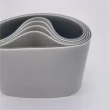 Coiled wide grey belts with smooth outer surfaces and toothed inner faces.