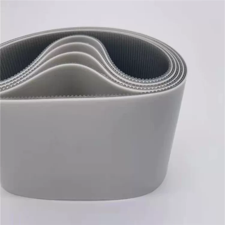 Coiled wide grey belts with smooth outer surfaces and toothed inner faces.