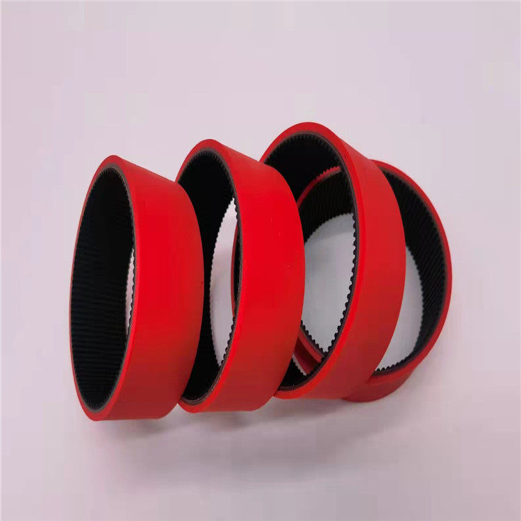 Red timing belts arranged in upright loops with dark toothed inner surfaces.